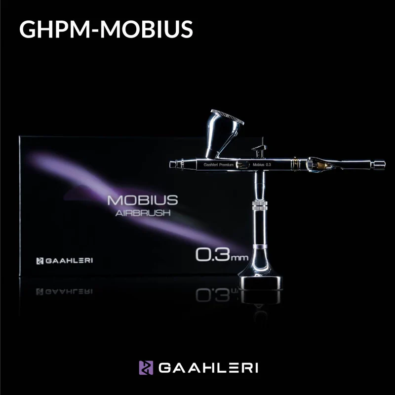 A Gaahleri GHPM-Mobius airbrush with a 0.3 mm nozzle displayed in front of its black packaging box with purple highlights and the text